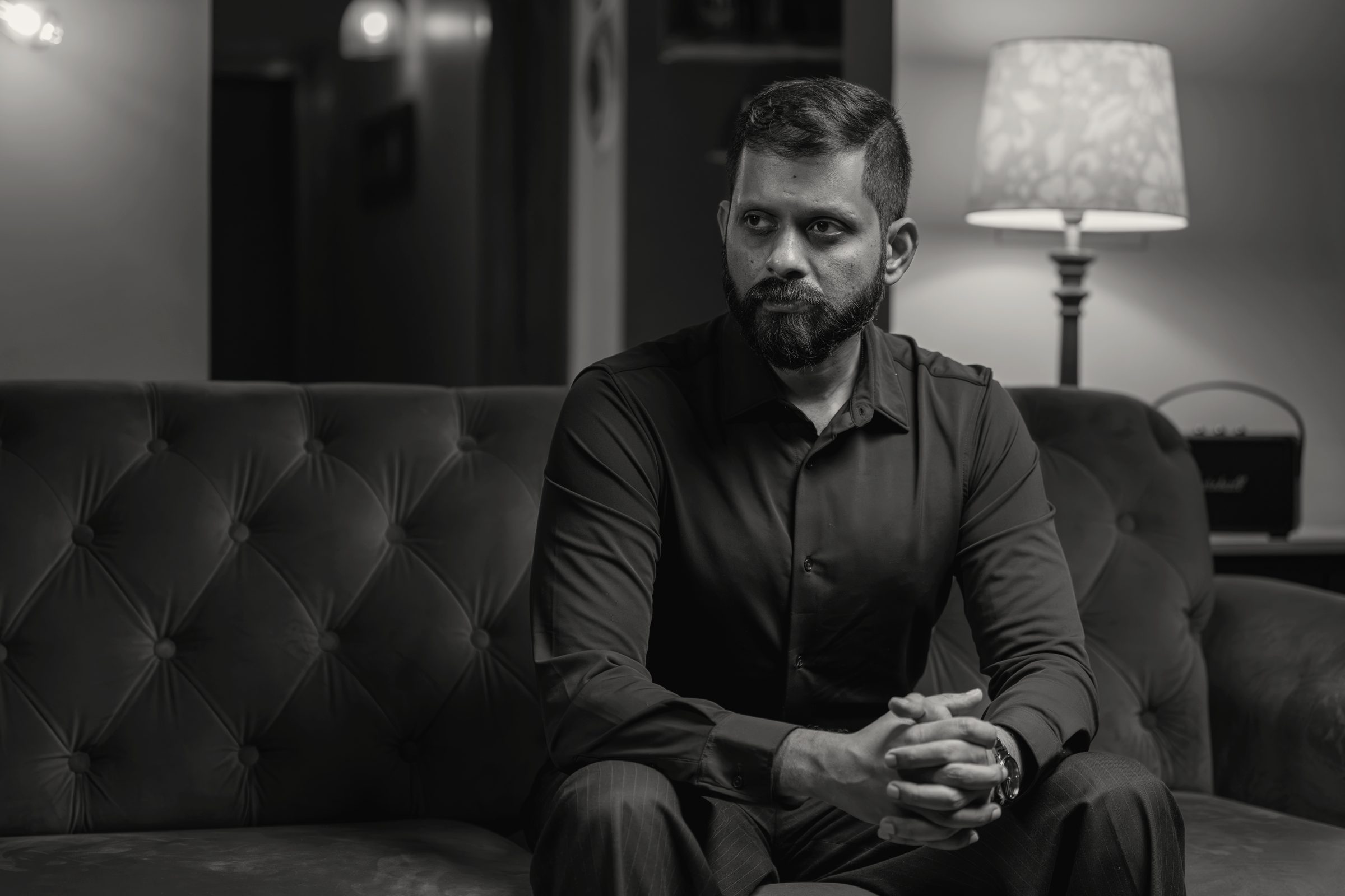 Shashank seated in the room, lamps lit behind him.