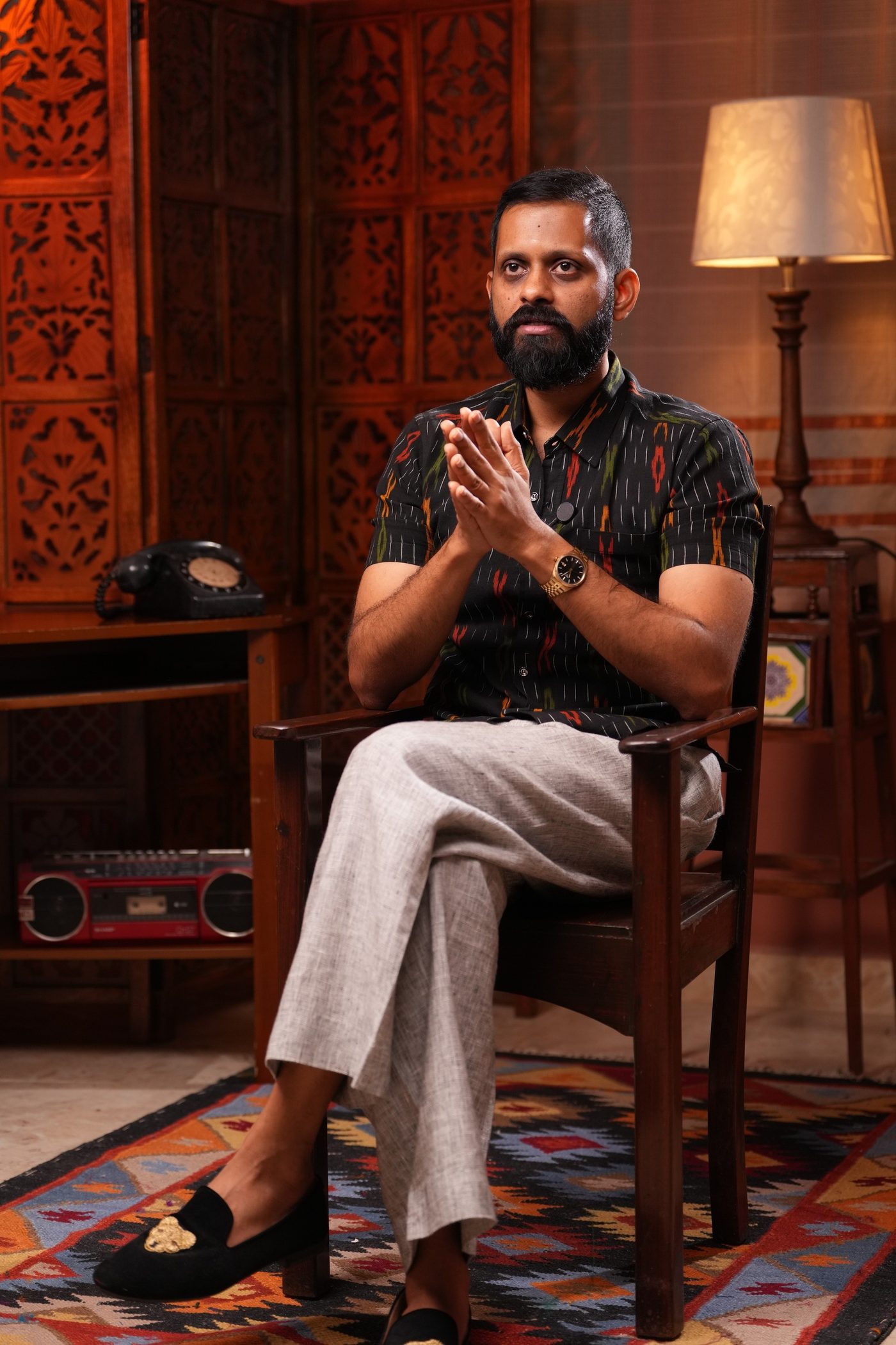 Shashank, seated, looking into the room.