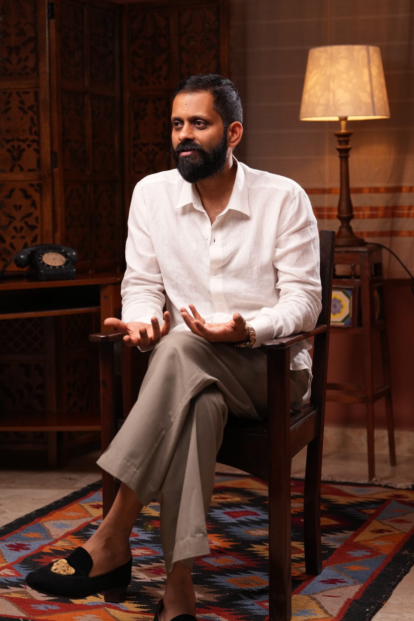 Shashank, seated, looking into the room.
