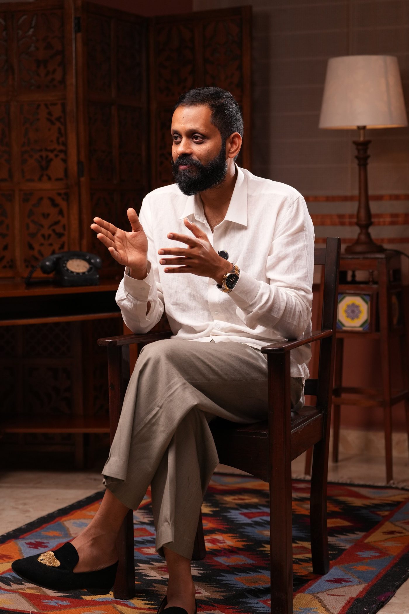 Shashank, seated, hands together.